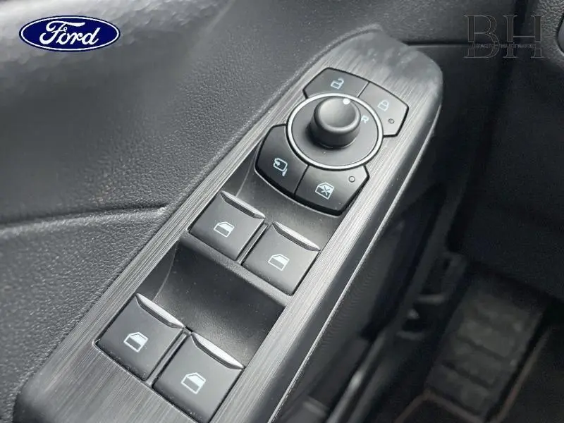 Gros plan sur les commandes de vitres et rétroviseurs côté conducteur du Ford Kuga gris Magnetic Métallisé 2023.