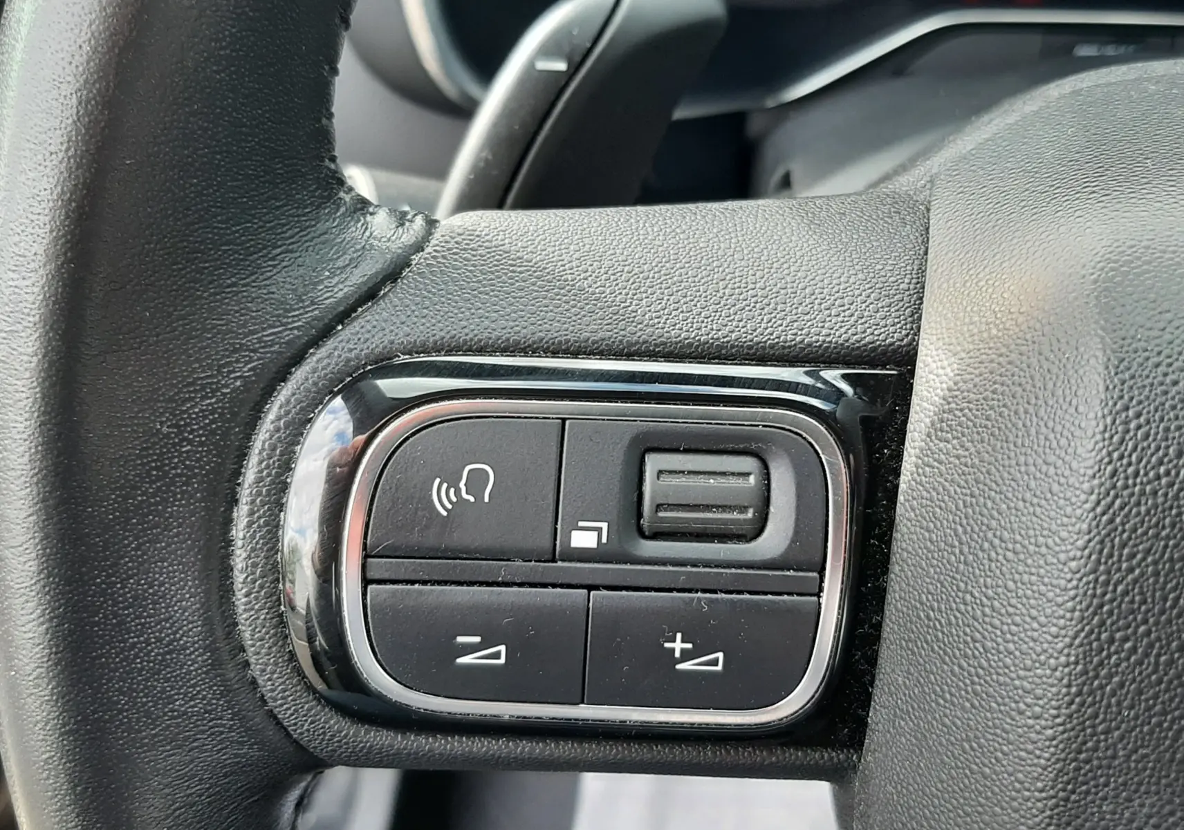 Gros plan sur les commandes gauche du volant noir du Citroën C5 Aircross 2020, avec boutons de volume et appel.