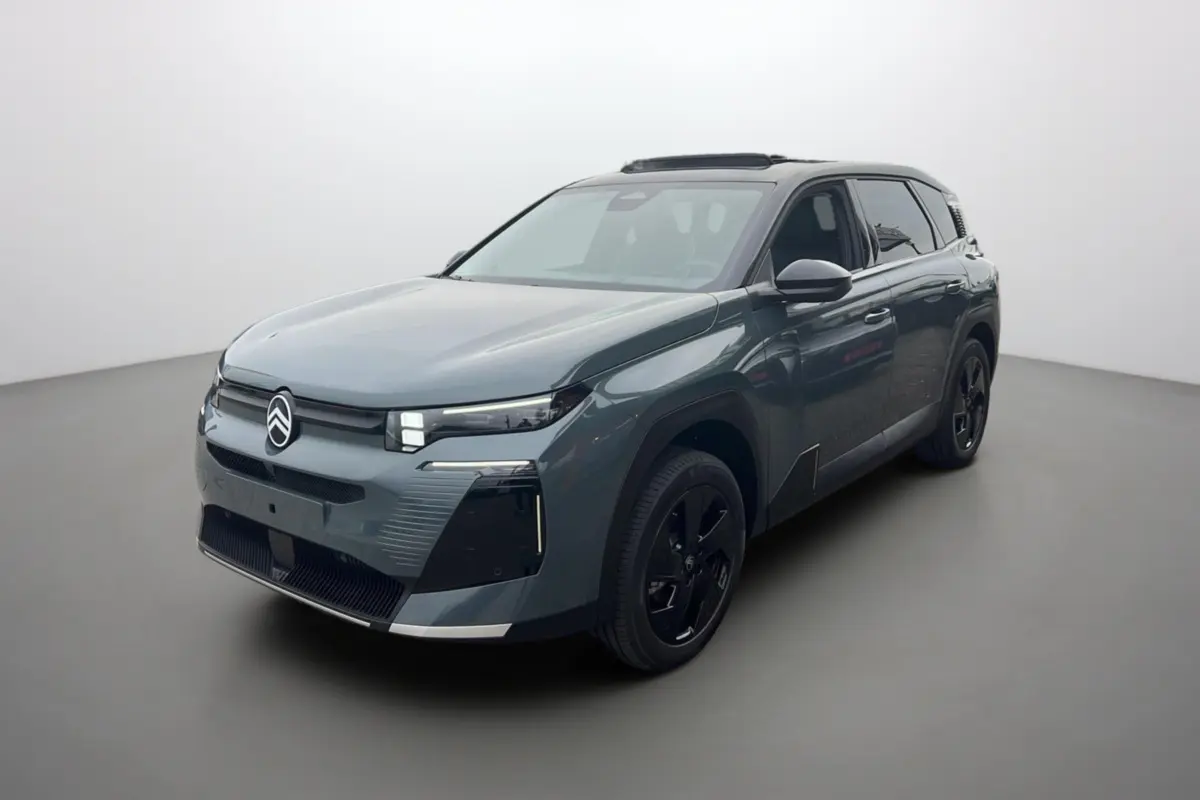 Vue 3/4 avant du Citroën C5 Aircross vert Astoria avec toit noir et jantes noires dans un studio lumineux.