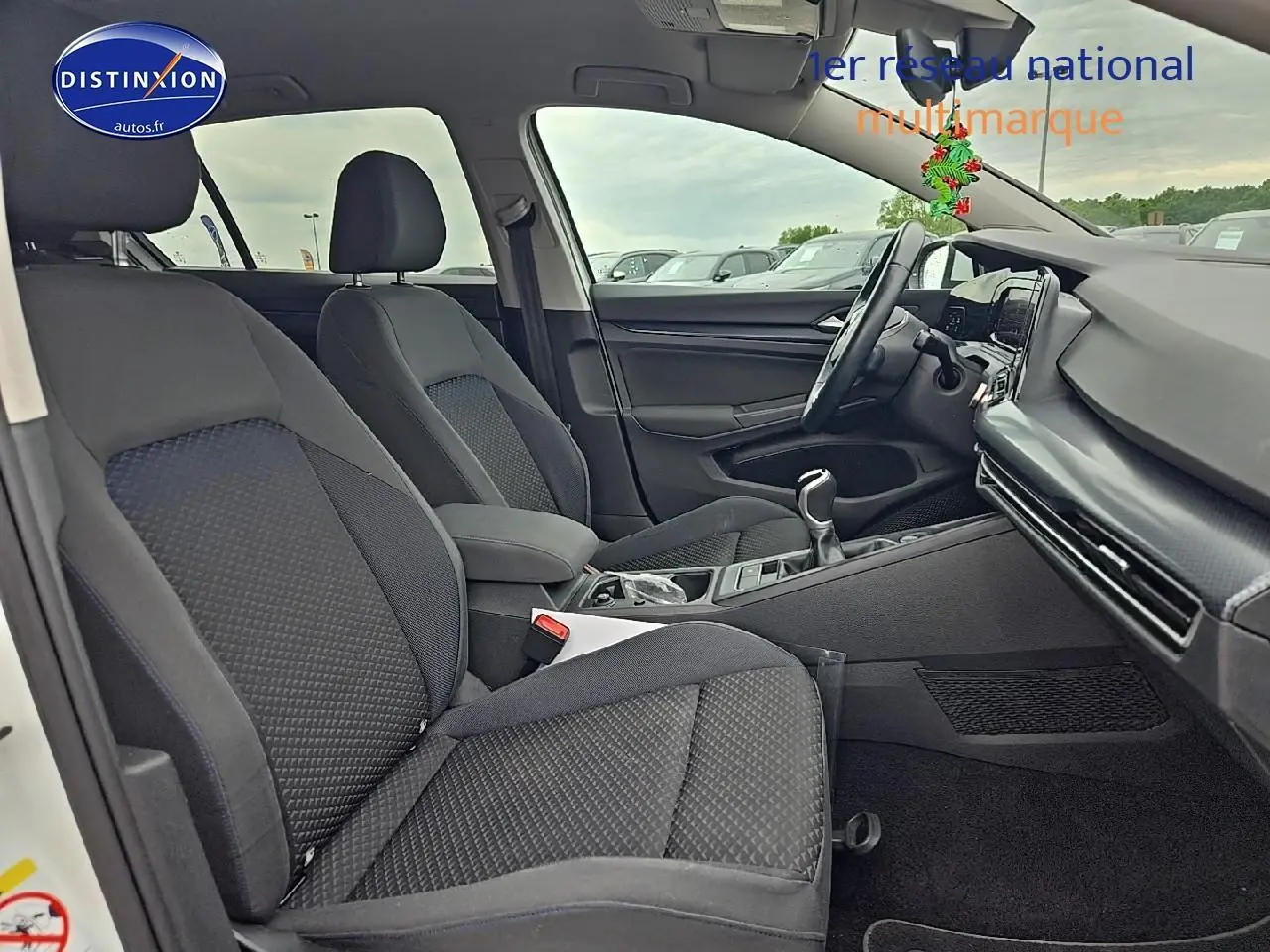 Vue intérieure côté droit de la Volkswagen Golf 1.5 TSI 2021 avec sièges tissu noirs et tableau de bord moderne.