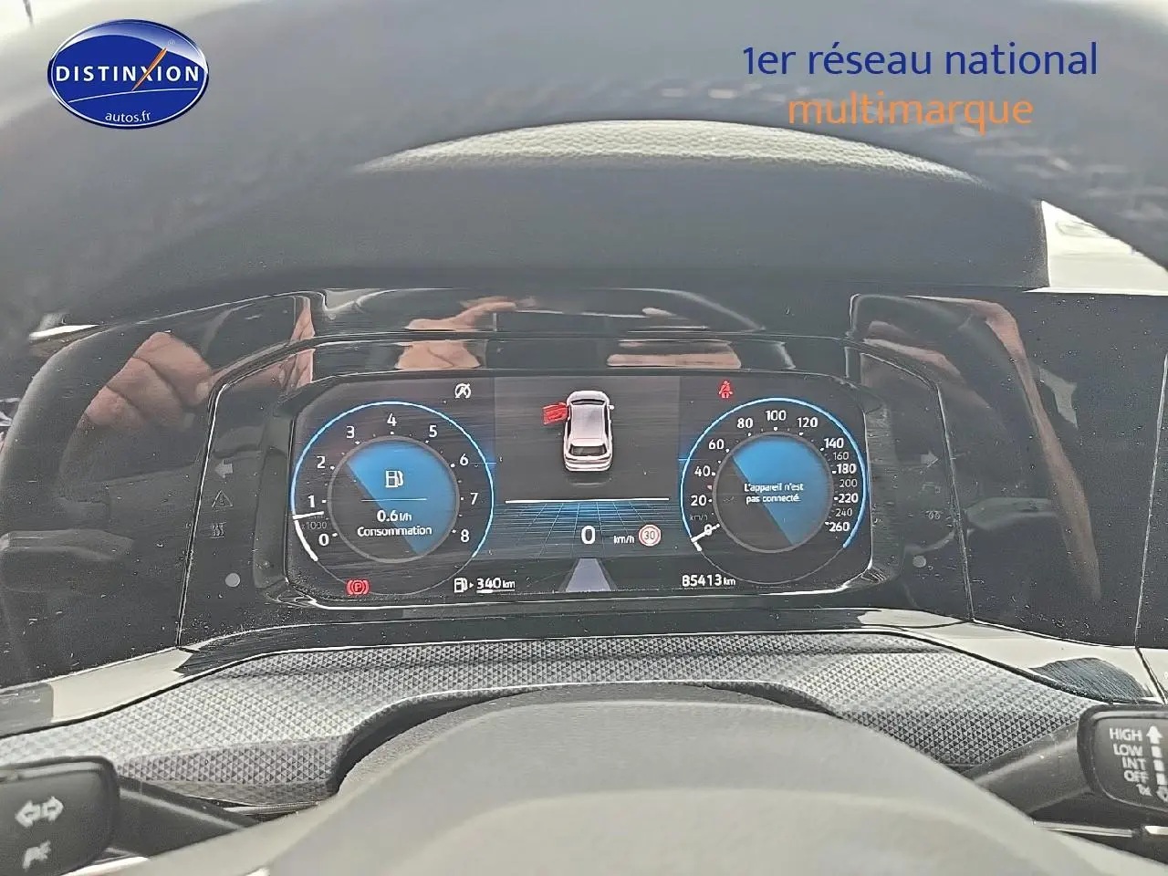 Vue du tableau de bord numérique de la Volkswagen Golf blanche, affichant la consommation et la vitesse à 0 km/h.