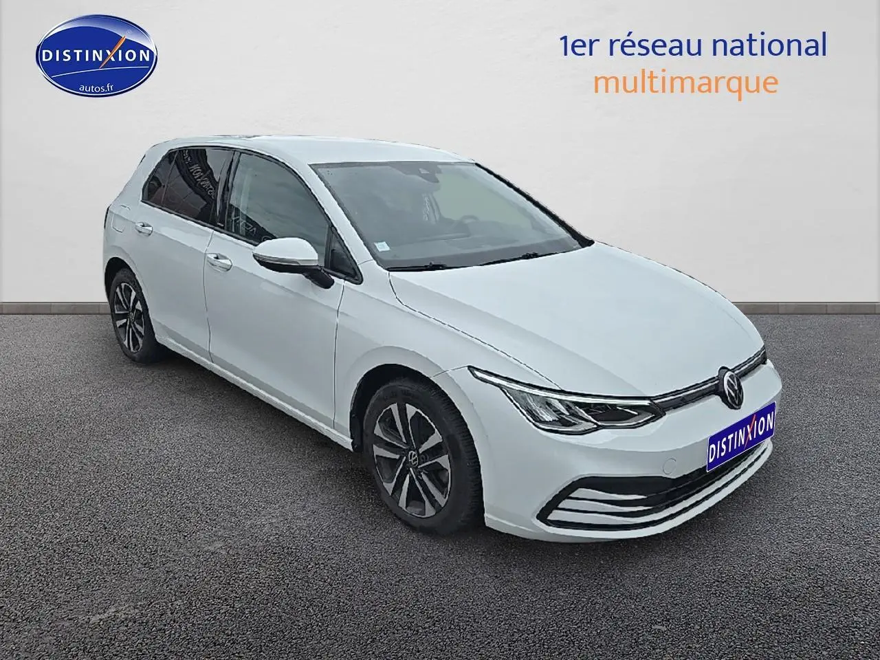 Vue 3/4 avant gauche d'une Volkswagen Golf blanche avec jantes alu et phares LED modernes.