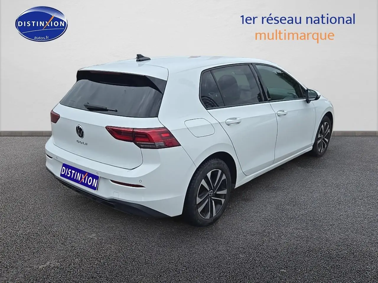 Volkswagen Golf blanc vue 3/4 arrière droit avec vitres teintées et jantes alliage.
