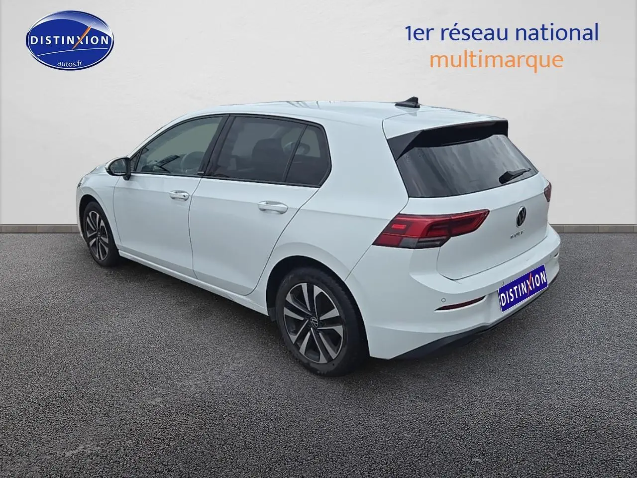 Vue 3/4 arrière droite d'une Volkswagen Golf blanche avec jantes alu et vitres teintées.