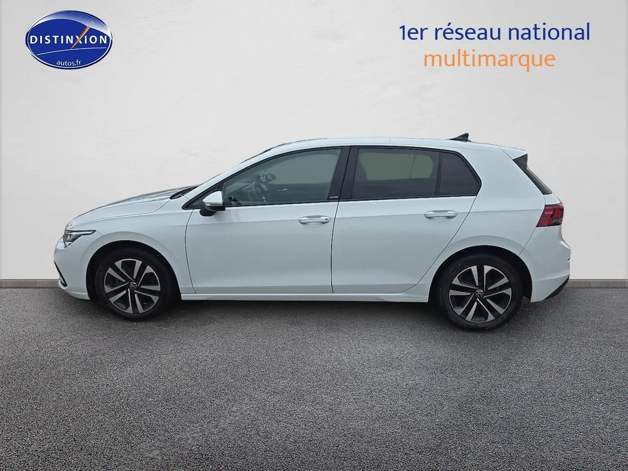 Profil droit d'une Volkswagen Golf blanche 2021 avec jantes alliage et vitres teintées sur fond neutre.