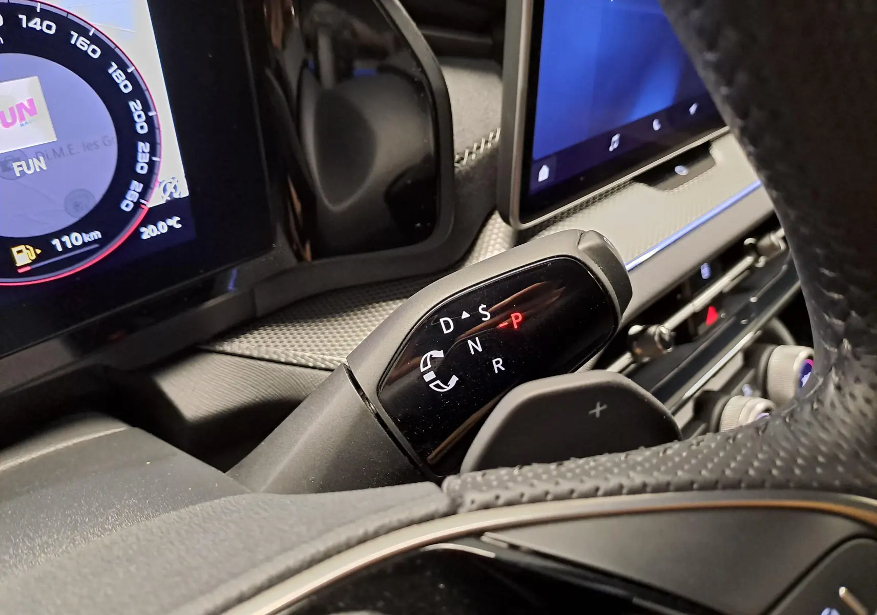 Gros plan sur la commande de boîte auto DSG7 du Skoda Kodiaq Bleu RS, avec tableau de bord numérique en arrière-plan.