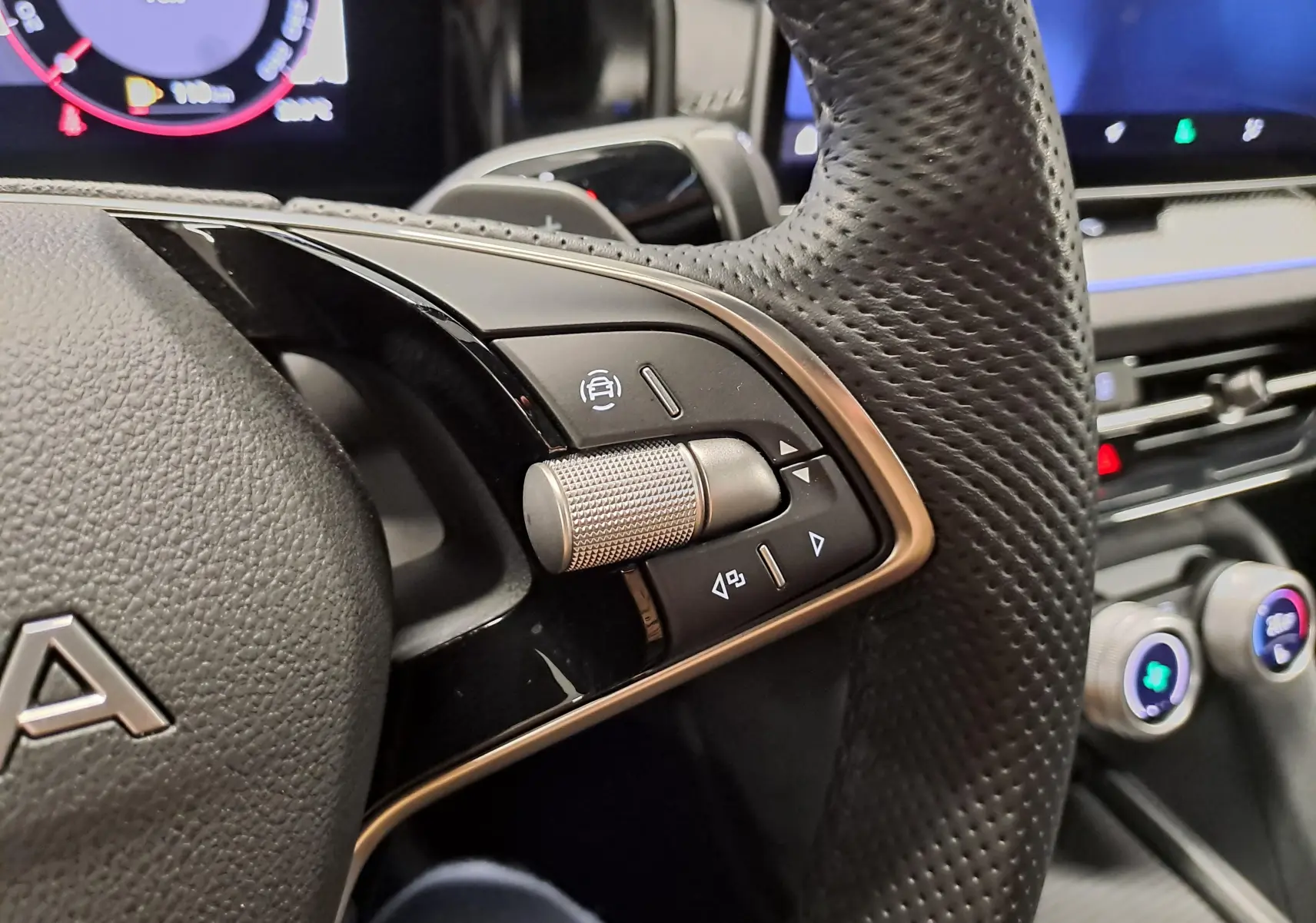 Gros plan sur les commandes au volant perforé du Skoda Kodiaq Sportline 2025, intérieur noir avec détails métalliques.