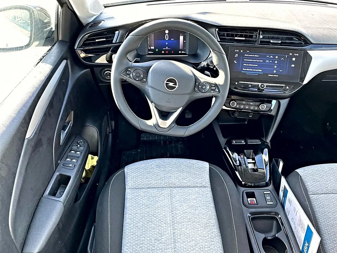 Vue intérieure frontale de l'Opel Corsa 2025 gris, avec volant multifonction, écran tactile et sièges tissu gris.