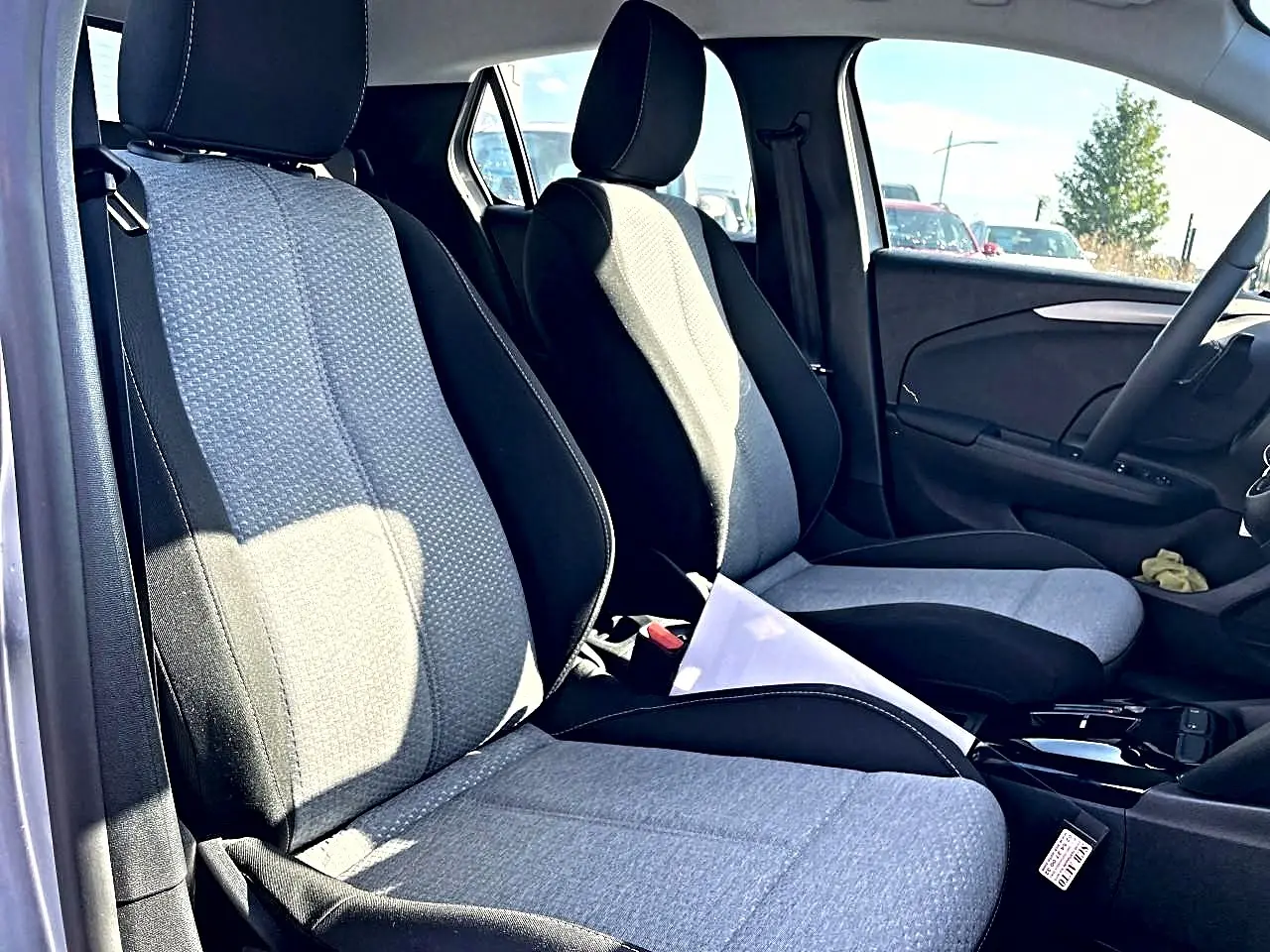 Vue intérieure côté conducteur de la banquette et siège avant en tissu gris et noir de l’Opel Corsa 2025.