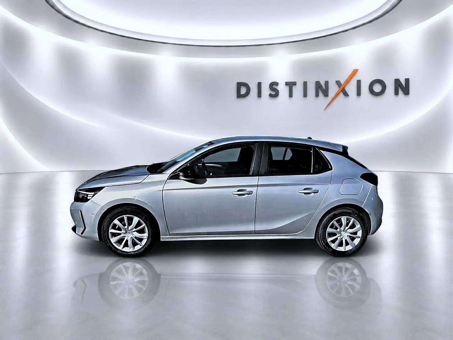 Opel Corsa gris vue de profil côté gauche, avec toit noir et jantes alliage, sur fond lumineux "DISTINXION".