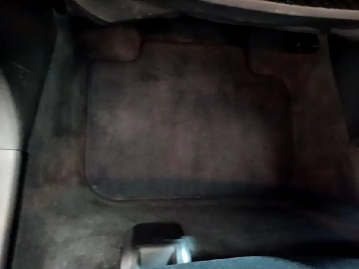 Tapis de sol noir côté conducteur dans l'habitacle d'une BMW X1 sDrive18i Lounge blanche de 2019.