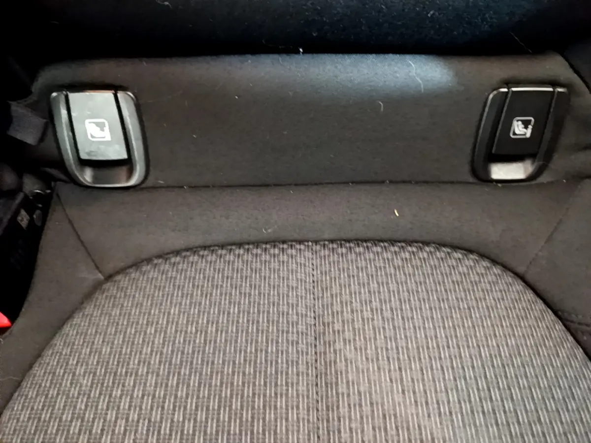 Gros plan sur les commandes de rabattement des sièges arrière du BMW X1 sDrive18i Lounge 2019, tissu gris.