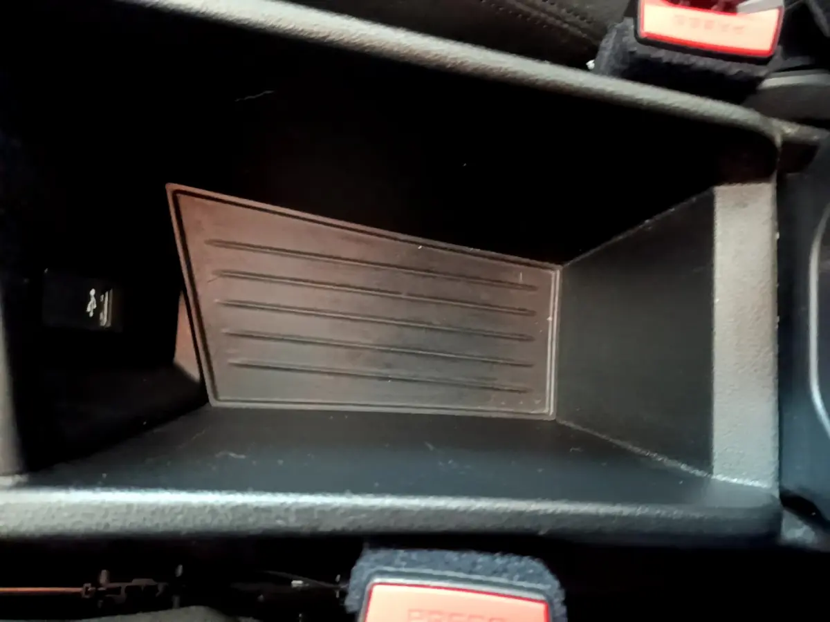 Gros plan sur le rangement central noir de la BMW X1 sDrive18i Lounge 2019, avec bouton USB visible à gauche.