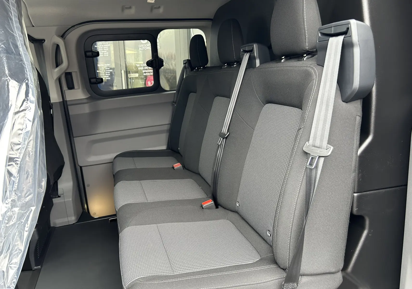 Vue intérieure côté droit des sièges arrière en tissu gris du Volkswagen Transporter T7 ProCab L1H1 Business.
