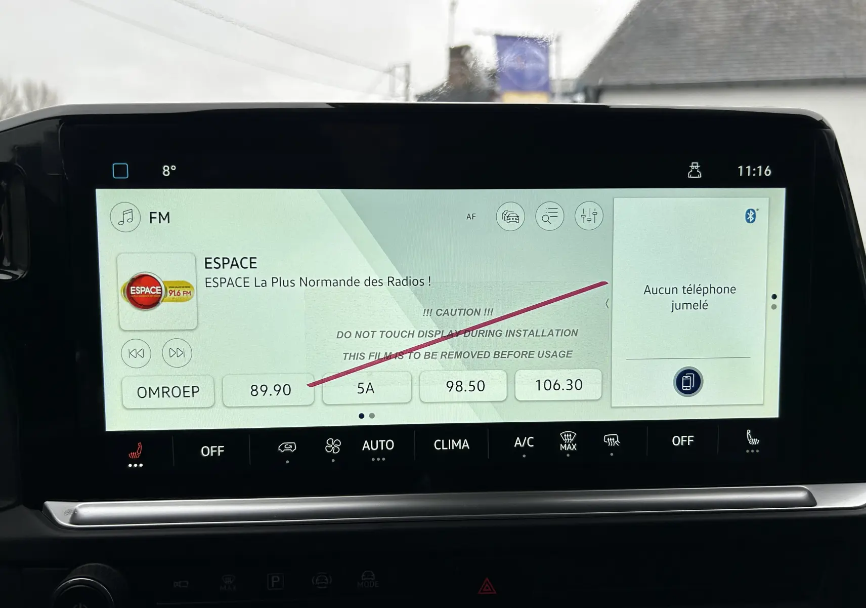 Écran tactile central du Volkswagen Transporter T7 ProCab affichant la radio FM et les commandes de climatisation.