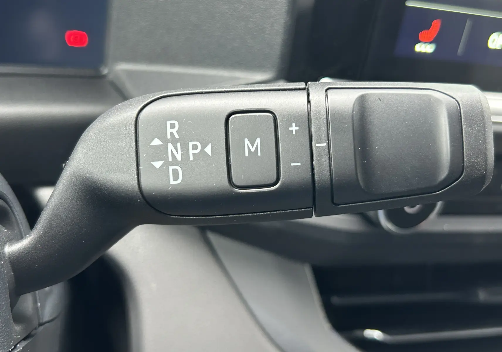 Gros plan sur la commande de boîte automatique avec sélecteur de vitesses et mode manuel dans un Volkswagen Transporter T7.