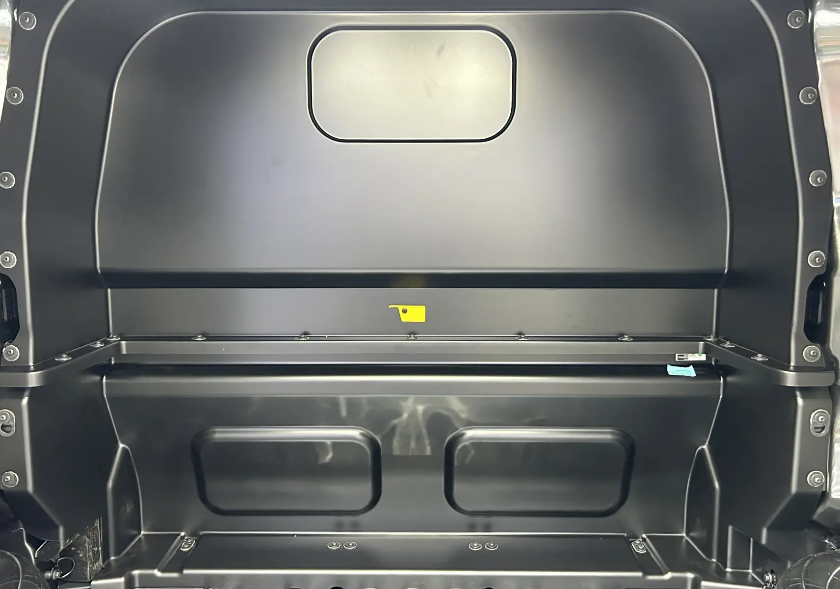 Vue intérieure arrière du Volkswagen Transporter T7 ProCab L1H1 Business en graphite, montrant la cloison métallique séparatrice.