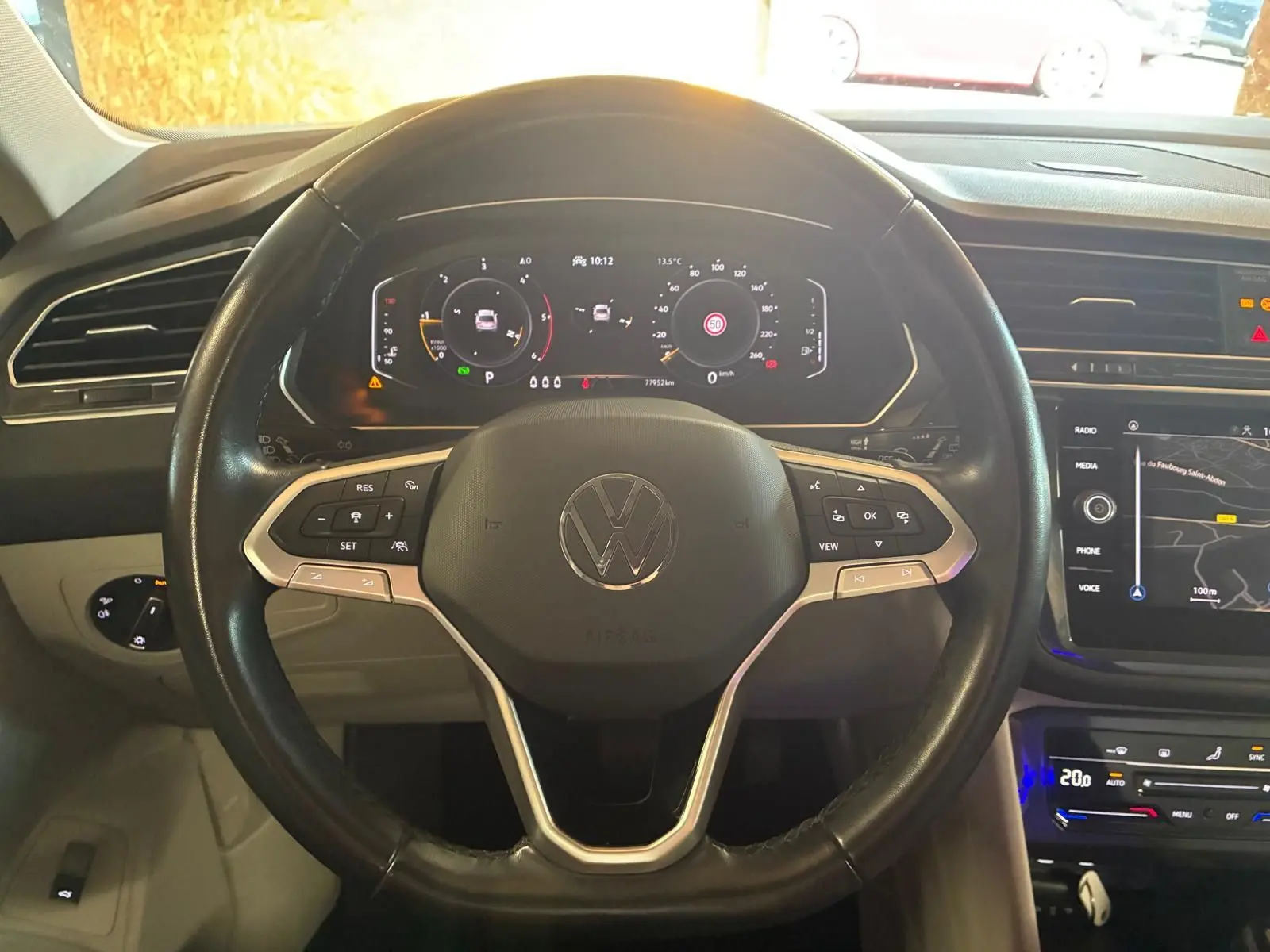 Vue rapprochée du volant noir du Volkswagen Tiguan 2023 avec tableau de bord digital et écran tactile de navigation.