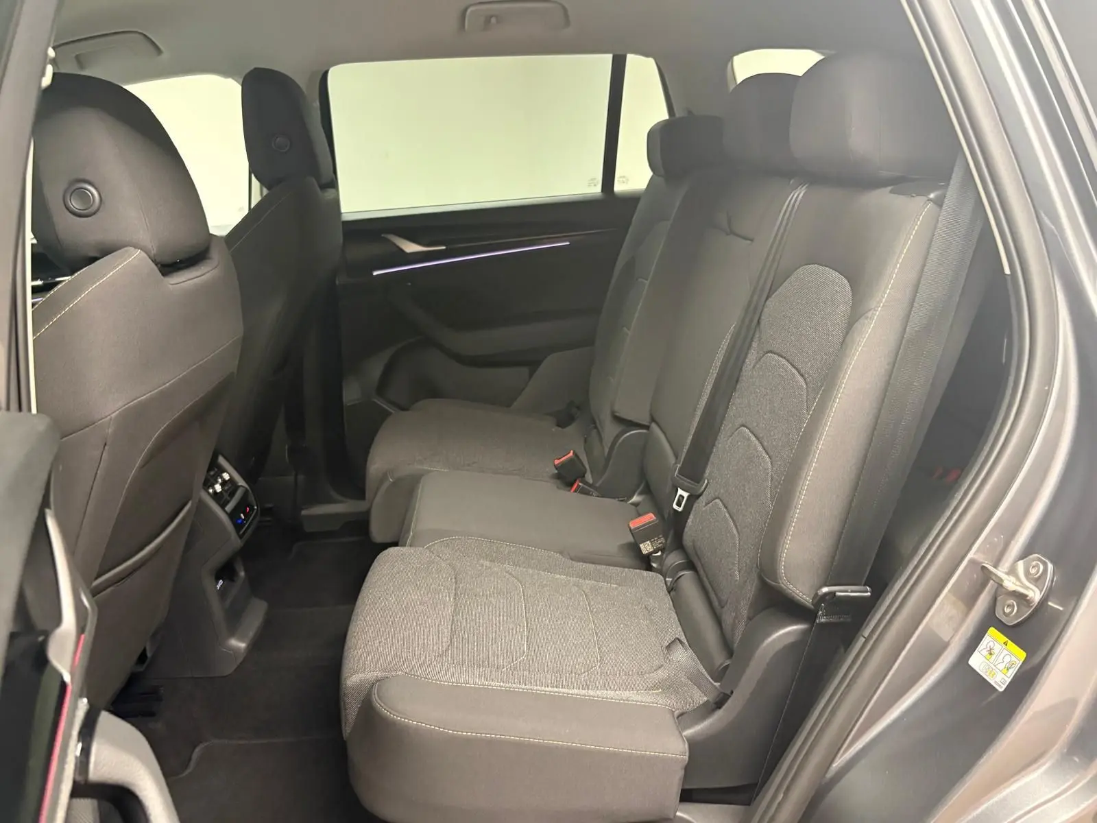 Vue intérieure côté droit des sièges arrière en tissu gris du Skoda Kodiaq 2025 gris graphite, version 7 places.