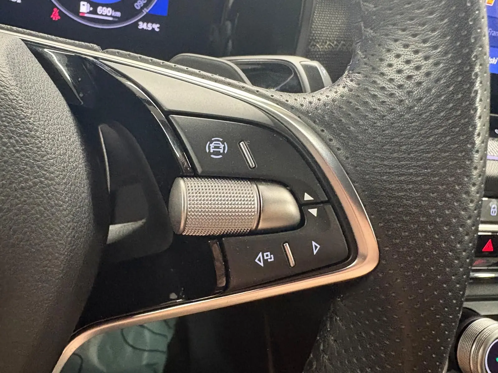 Gros plan sur les commandes au volant côté gauche du Skoda Kodiaq gris graphite 2025, avec molette texturée et boutons tactiles.