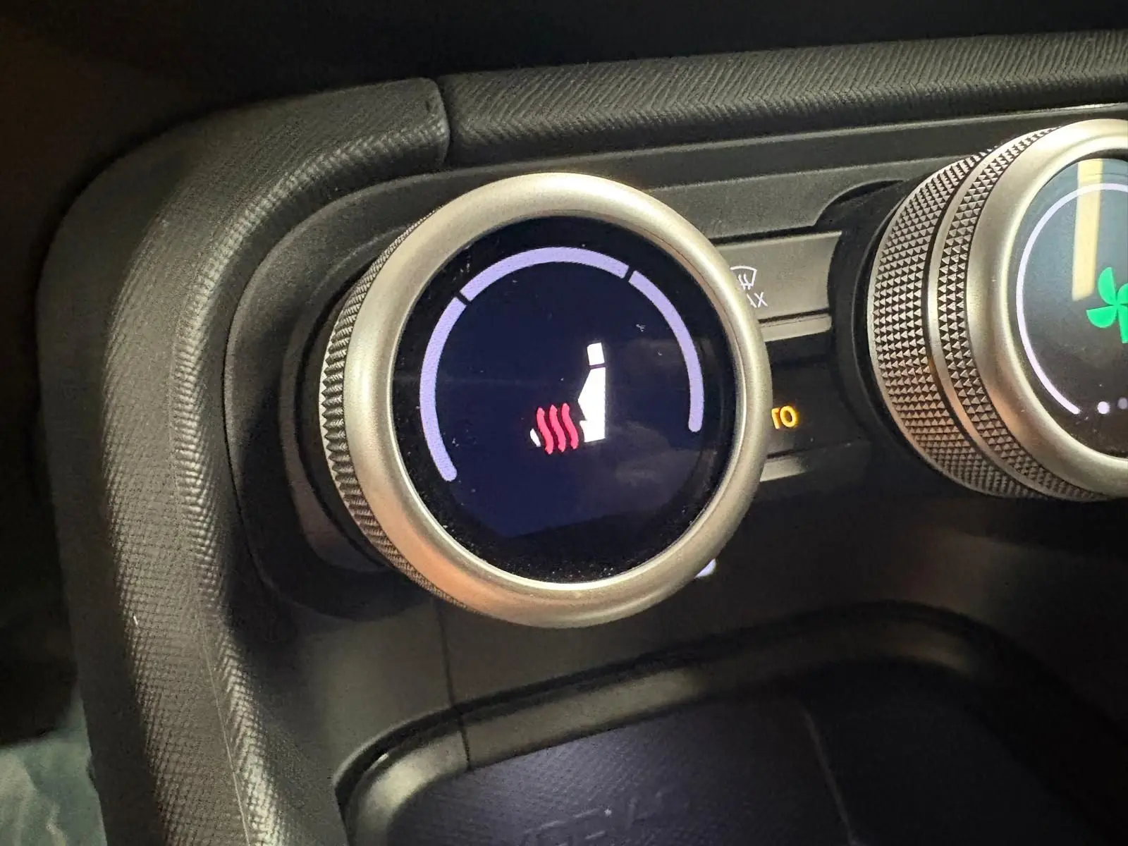 Gros plan sur le bouton de réglage du siège chauffant dans l’habitacle du Skoda Kodiaq gris graphite 2025.