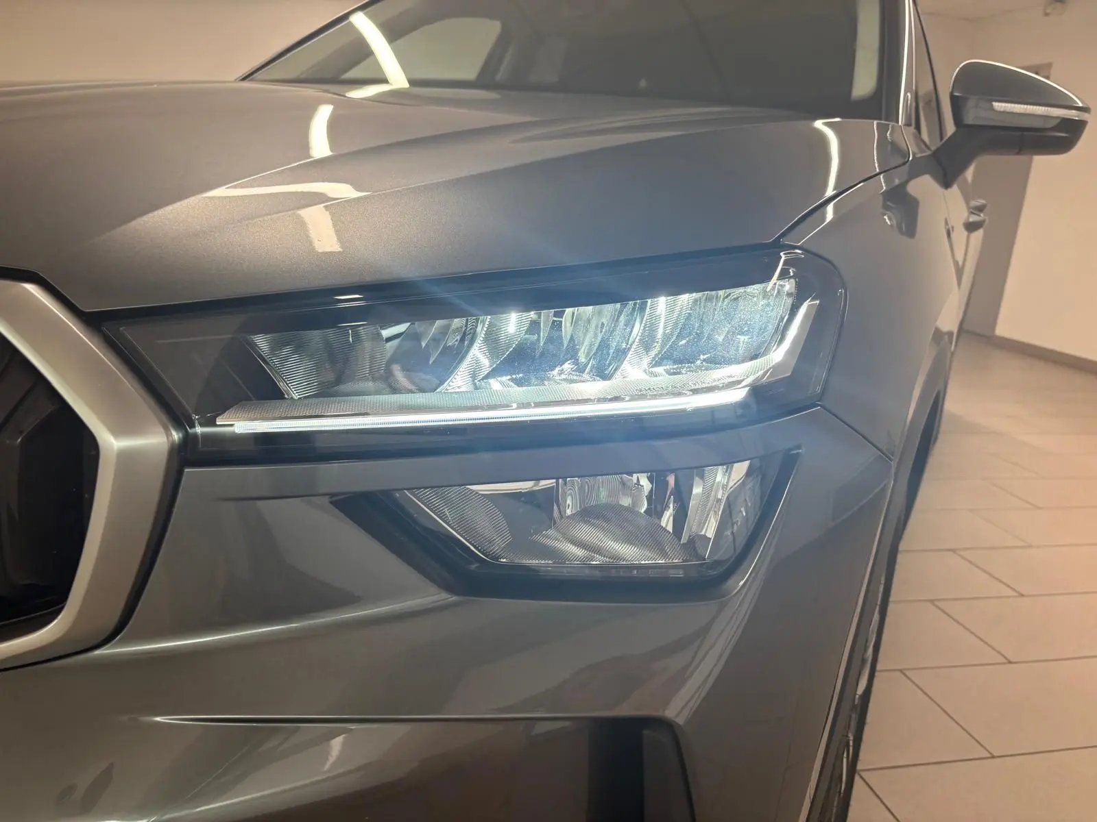 Gros plan sur le phare avant droit du Skoda Kodiaq gris graphite 2025, mettant en valeur son design moderne et précis.