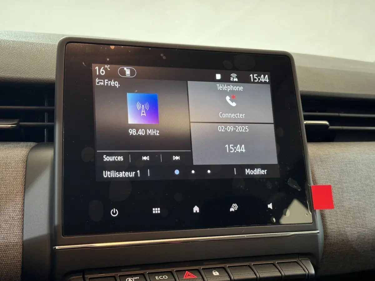 Écran tactile central de la Renault Clio gris clair 2025 affichant radio et menu téléphone.