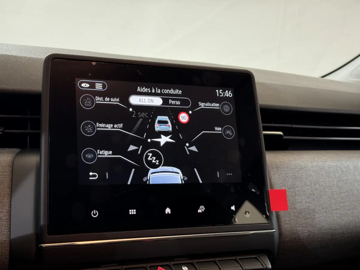 Écran tactile central de la Renault Clio gris clair 2025 affichant les aides à la conduite en intérieur.