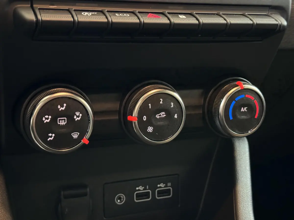 Gros plan sur les commandes de climatisation et les ports USB du tableau de bord de la Renault Clio gris clair Evolution Blue dCi 100 2025.