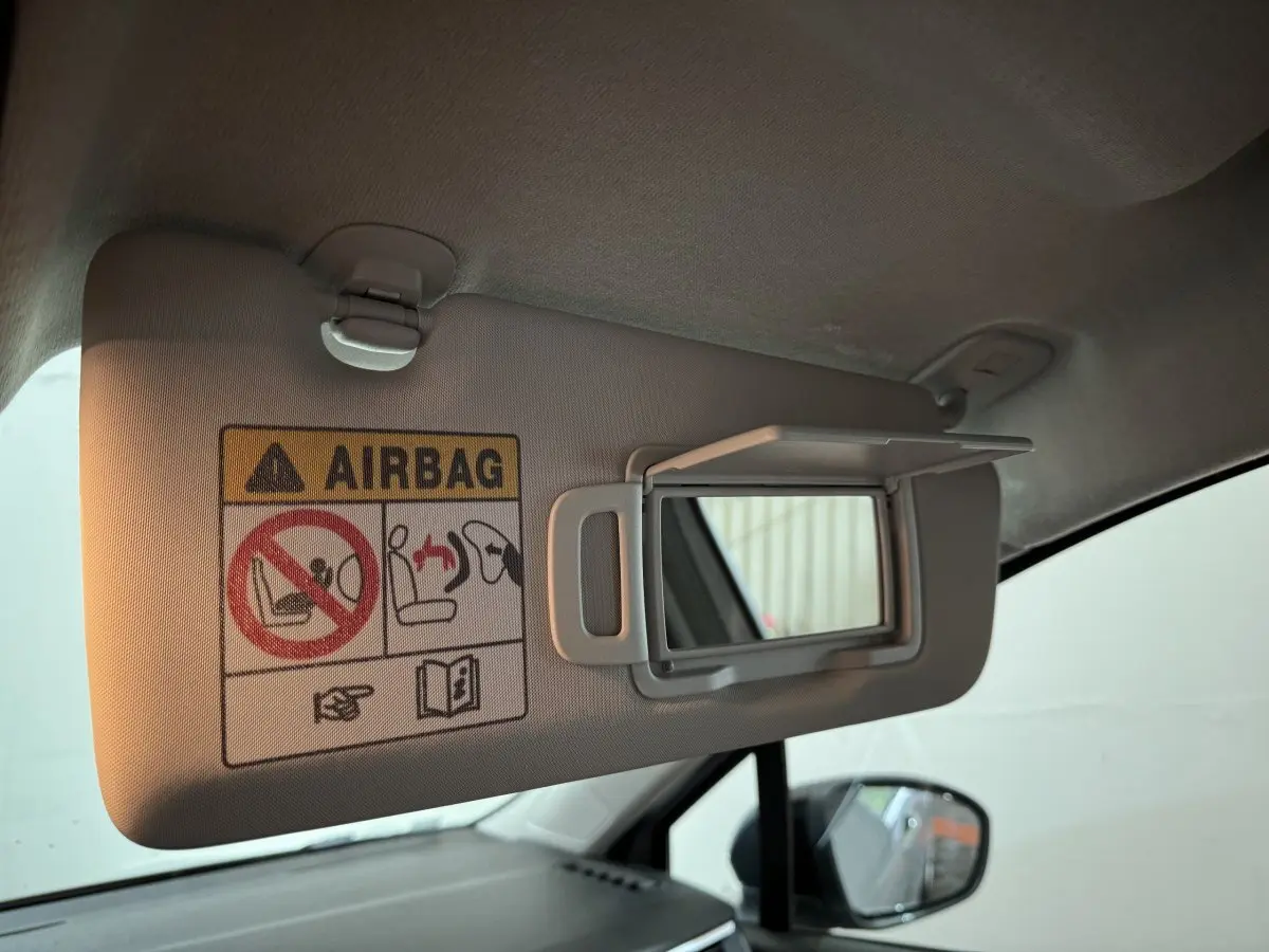 Détail du pare-soleil côté conducteur avec miroir et avertissement airbag dans une Renault Clio gris clair 2025.