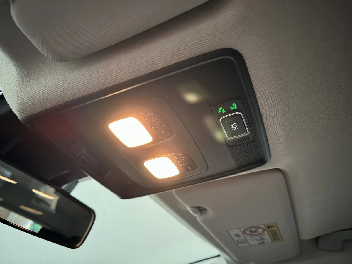 Plafonnier intérieur allumé avec bouton SOS et miroir de courtoisie dans une Renault Clio gris clair 2025.