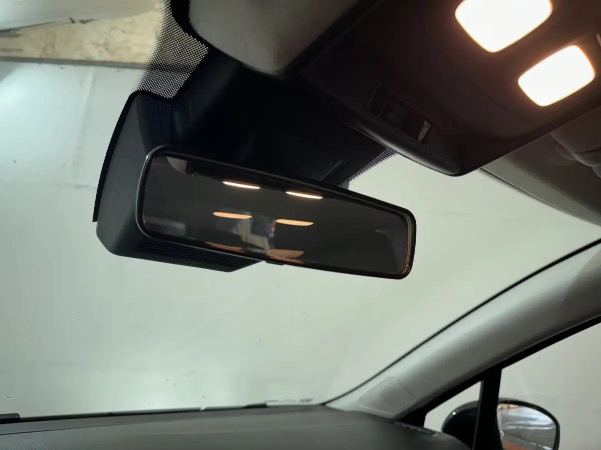 Vue intérieure rapprochée du rétroviseur central et du plafonnier éclairé d'une Renault Clio gris clair 2025.