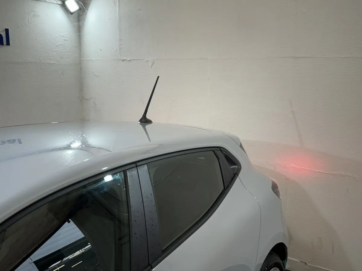Vue arrière côté gauche d'une Renault Clio gris clair 2025, avec antenne de toit et vitres teintées.