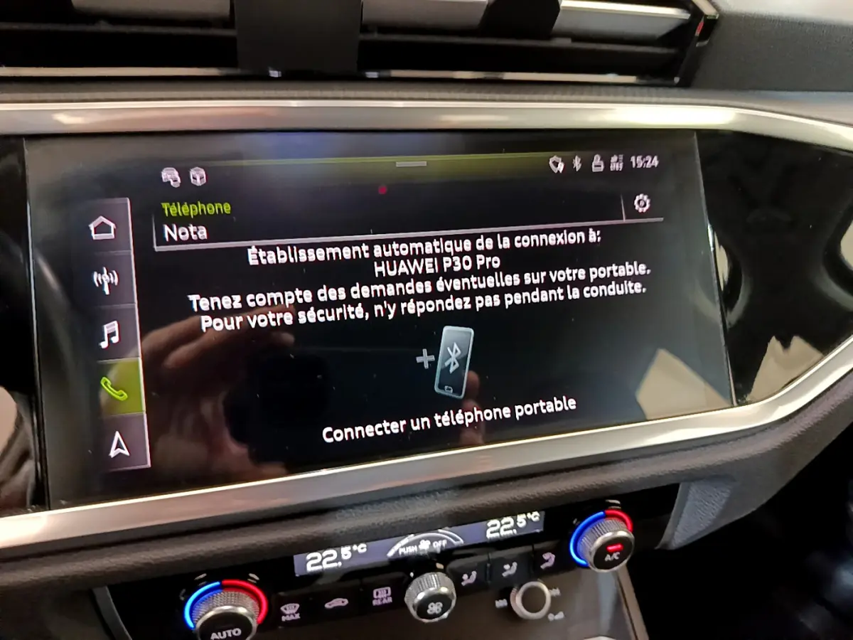 Écran tactile central de l’Audi Q3 noir 2021 affichant la connexion Bluetooth avec un smartphone Huawei P30 Pro.