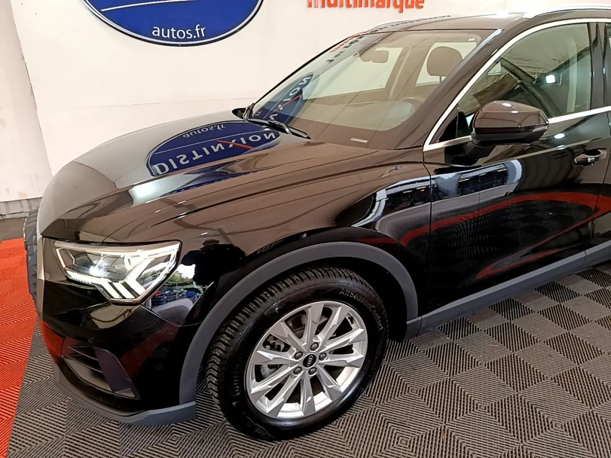 Audi Q3 noir vue 3/4 avant droit, mettant en valeur les phares LED et les jantes alliage argentées.