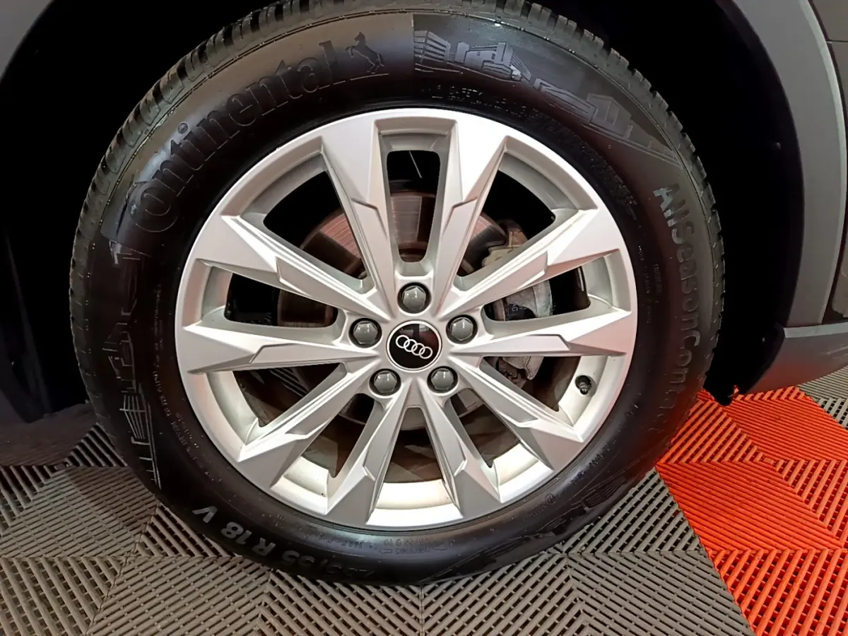 Gros plan sur la roue avant droite d’un Audi Q3 noir 35 TDI 150 S tronic avec jante argentée à plusieurs branches.