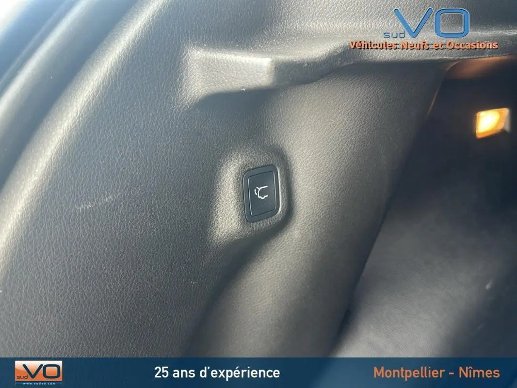 Bouton d'ouverture du hayon dans le coffre du Jeep Compass bleu 2023, vue intérieure côté droit.