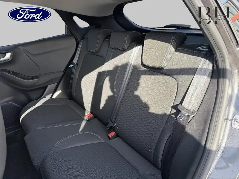 Vue latérale intérieure montrant la banquette arrière noire du Ford Puma 2020 avec ceintures et appuie-têtes.