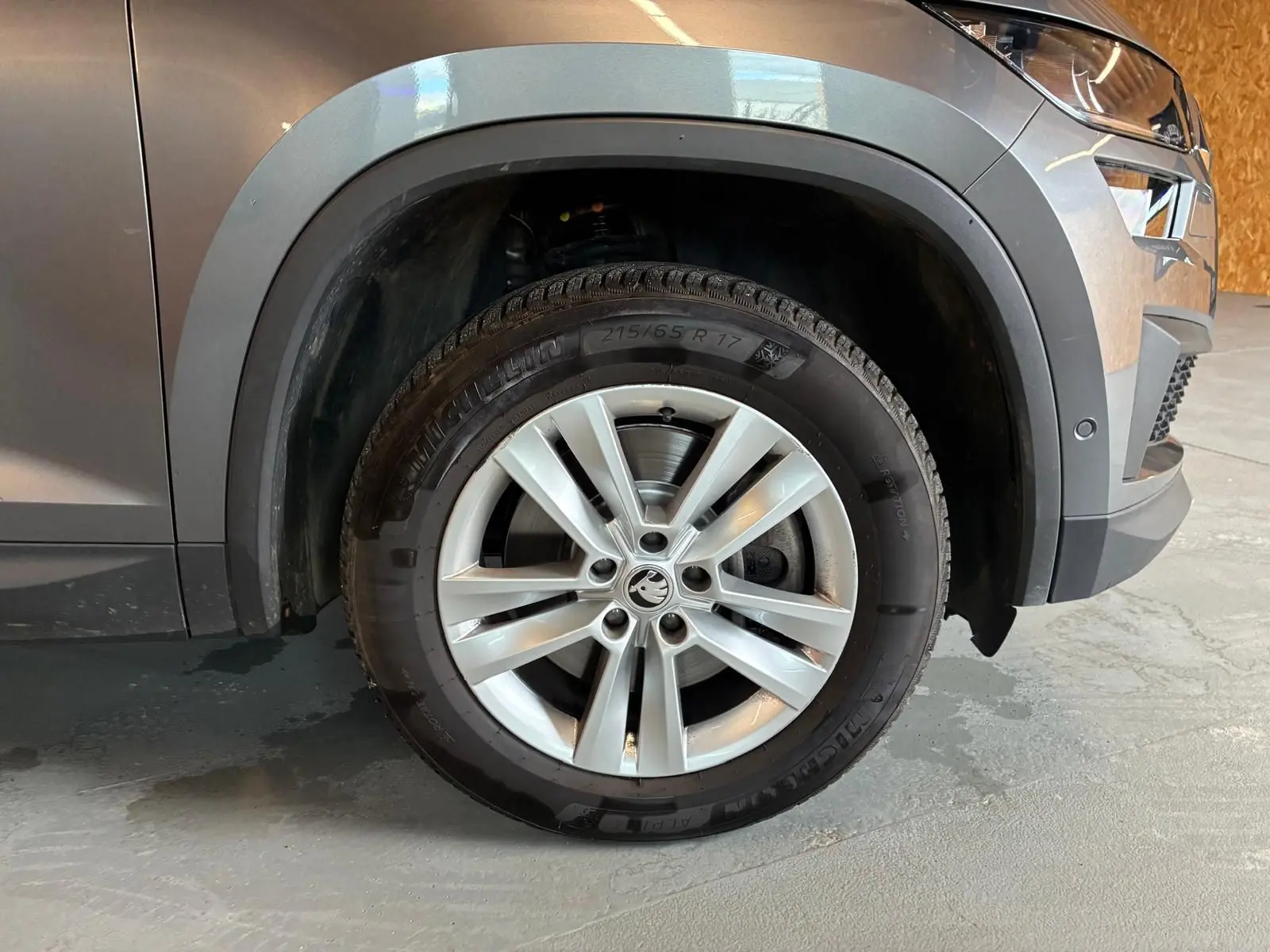 Gros plan sur la jante alu 17'' avant droite du Skoda Kodiaq gris avec protection noire des passages de roue.