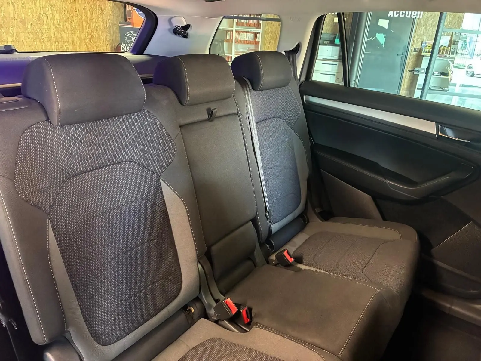Vue intérieure côté droit des sièges arrière en tissu noir du Skoda Kodiaq 7 places avec appuie-têtes et ceintures visibles.