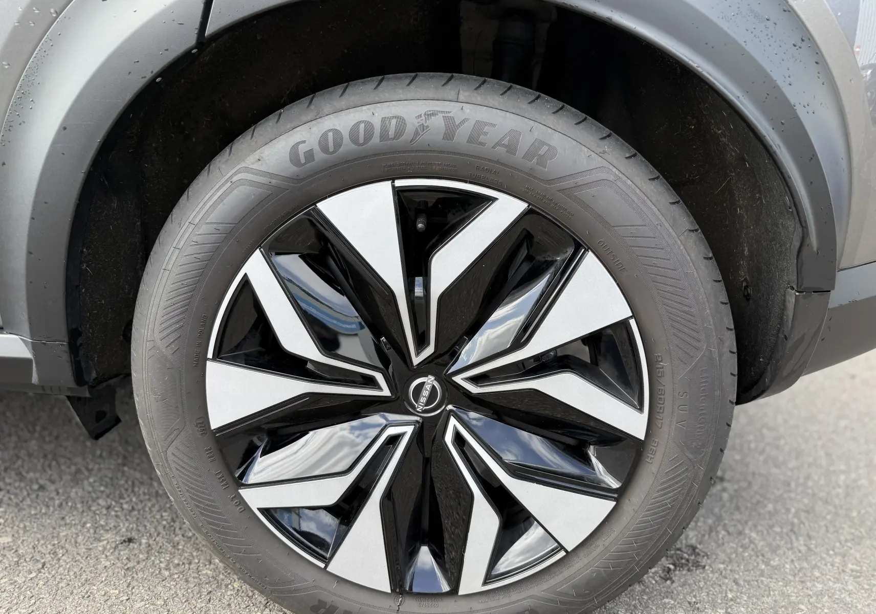 Gros plan sur la roue avant droite du Nissan Juke Hybrid 2025, jante bicolore noir et argent avec pneu Goodyear.