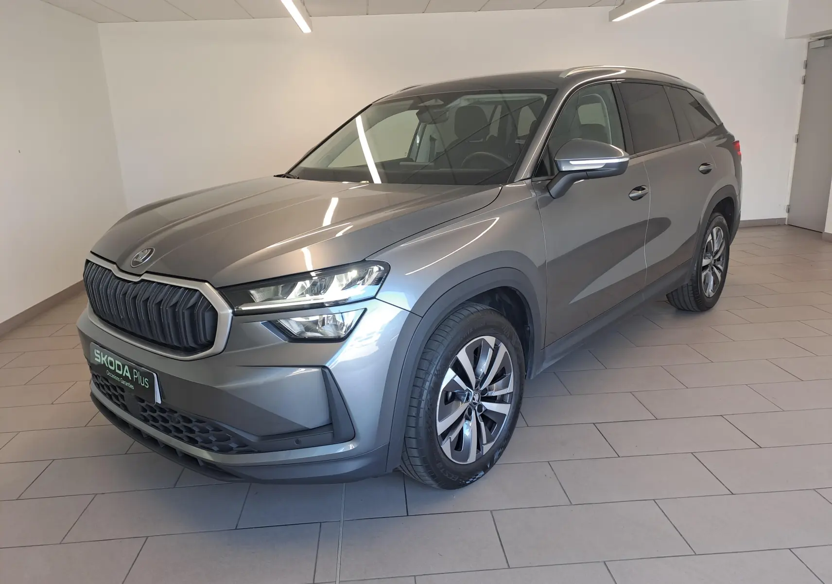 Skoda Kodiaq 2025 gris graphite vu en 3/4 avant droit, avec calandre imposante et jantes alliage distinctives.