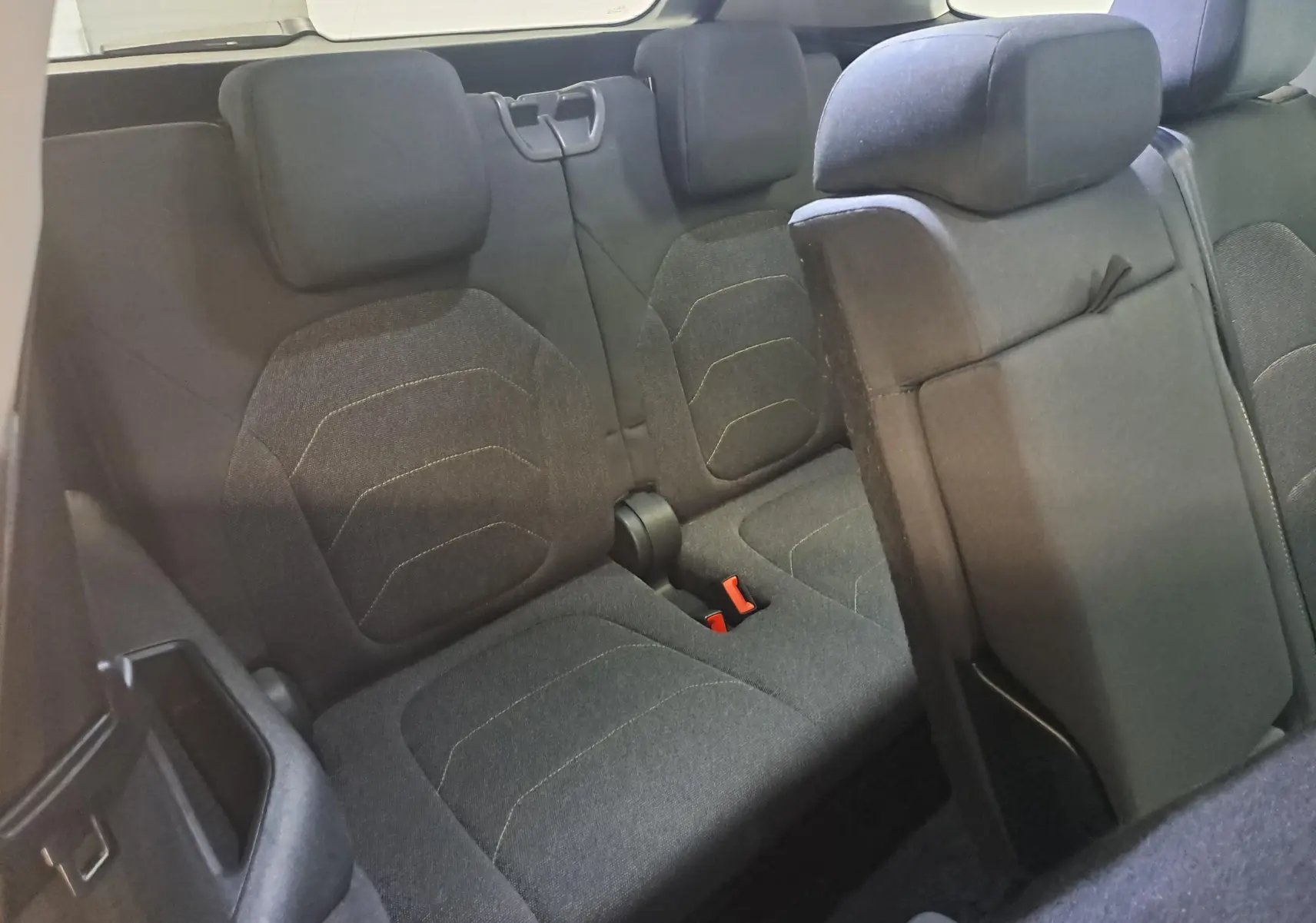 Vue intérieure arrière du siège 3e rangée du Skoda Kodiaq 2025 gris graphite, montrant les sièges en tissu noir avec appuie-têtes.