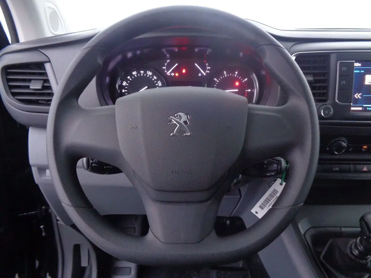 Vue rapprochée du volant noir du Peugeot Expert Fourgon 2022 avec tableau de bord et écran tactile visibles à droite.