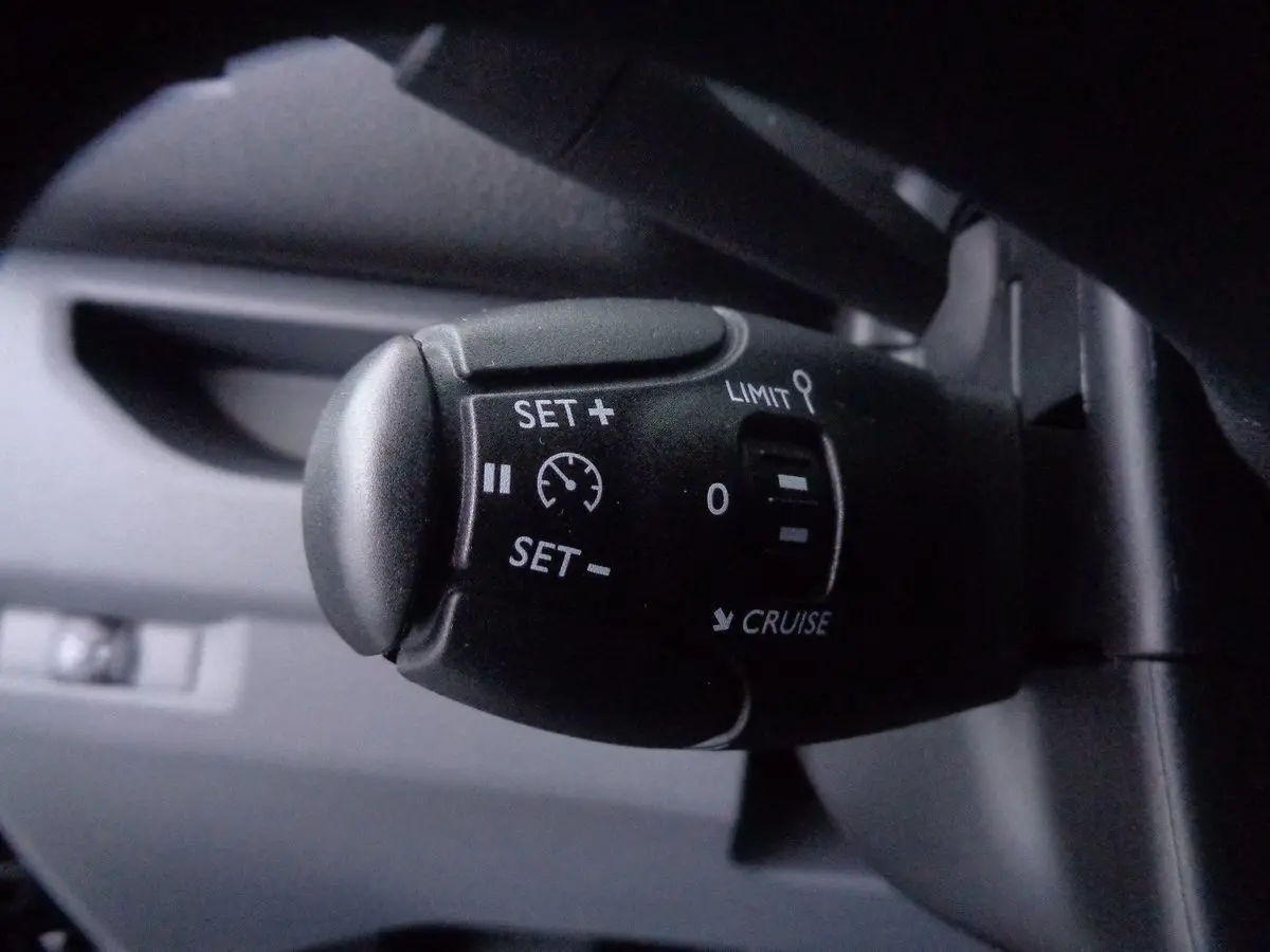 Gros plan sur la commande de régulateur de vitesse du Peugeot Expert Fourgon noir métal, intérieur conducteur.