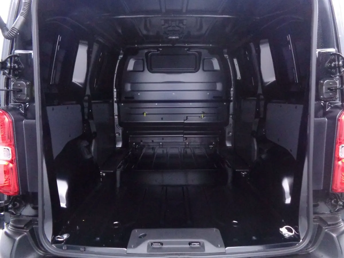Vue arrière ouverte du Peugeot Expert Fourgon noir métal 2022, montrant l'espace de chargement vide et la cloison intérieure.