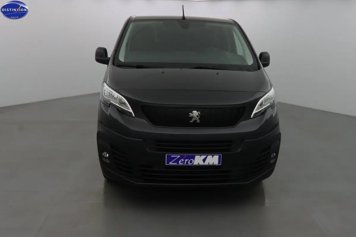 Vue frontale d'un Peugeot Expert Fourgon noir métal 2022 avec calandre noire et phares modernes allumés.