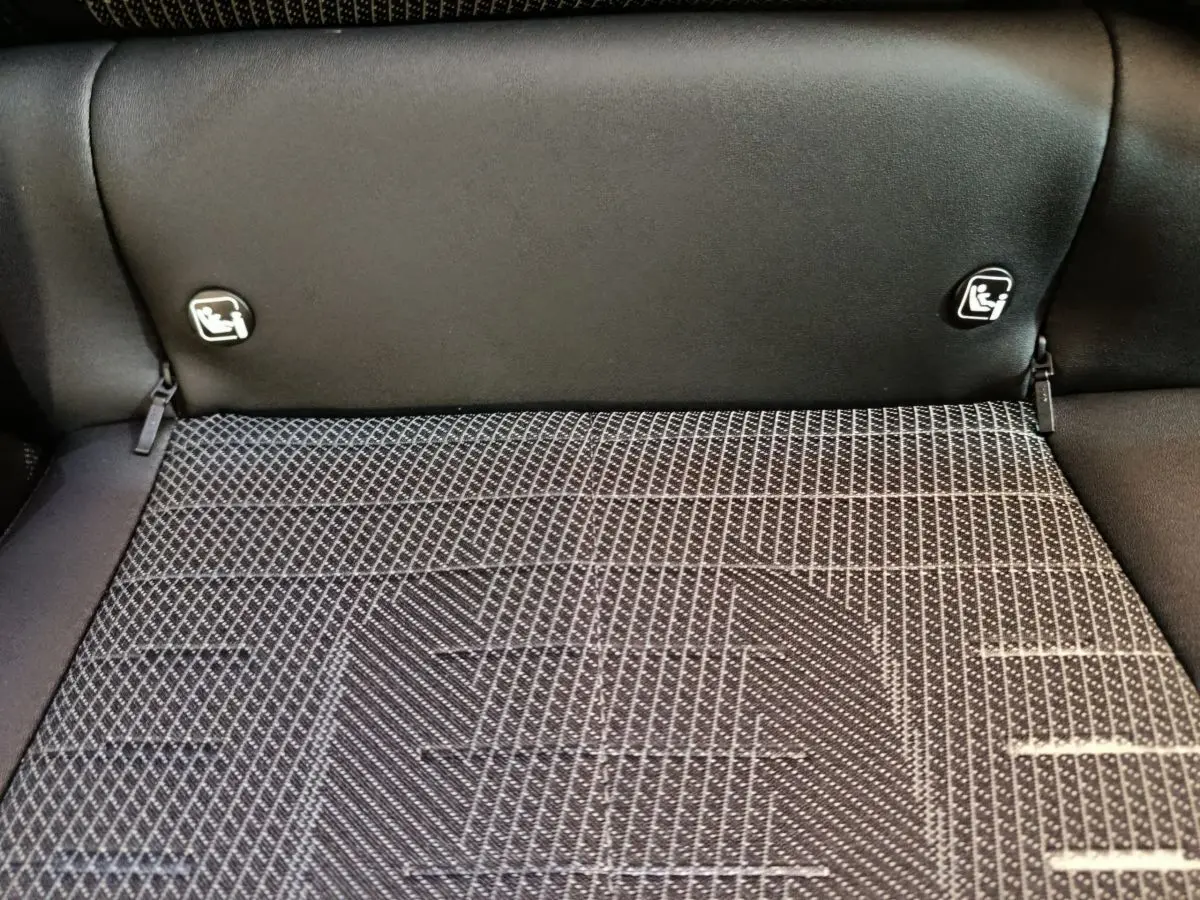 Gros plan sur la banquette arrière noire et la texture du coffre du Peugeot 3008 gris foncé hybride 2025.