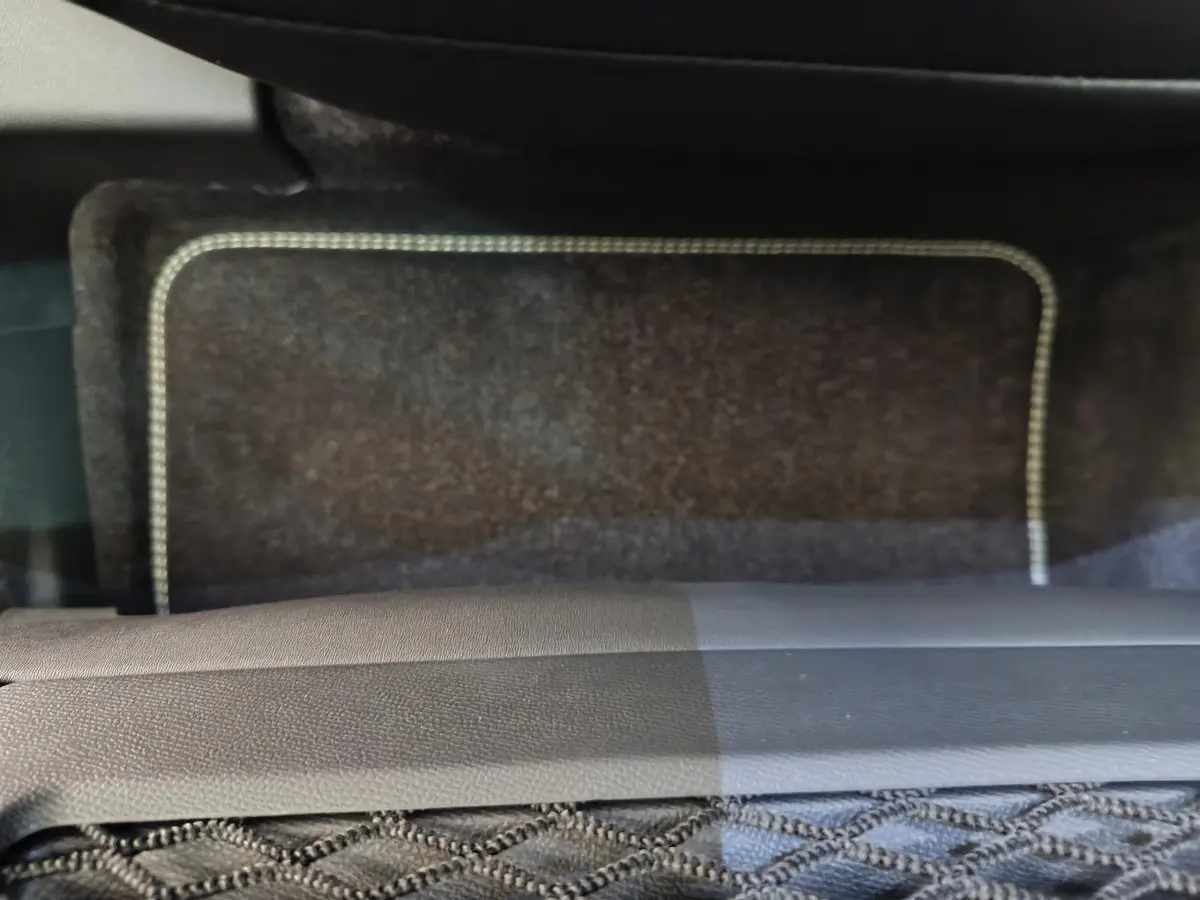 Gros plan sur le tapis de sol avant gris foncé du Peugeot 3008 1.2 HYBRID 145 E-DCS6 GT, intérieur sobre.