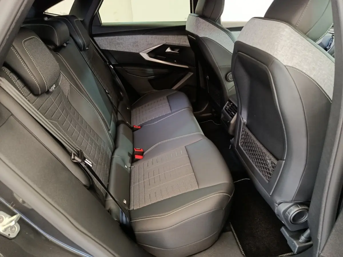 Vue côté droit de la banquette arrière en tissu et cuir gris du Peugeot 3008 1.2 HYBRID 145 E-DCS6 GT 2025.